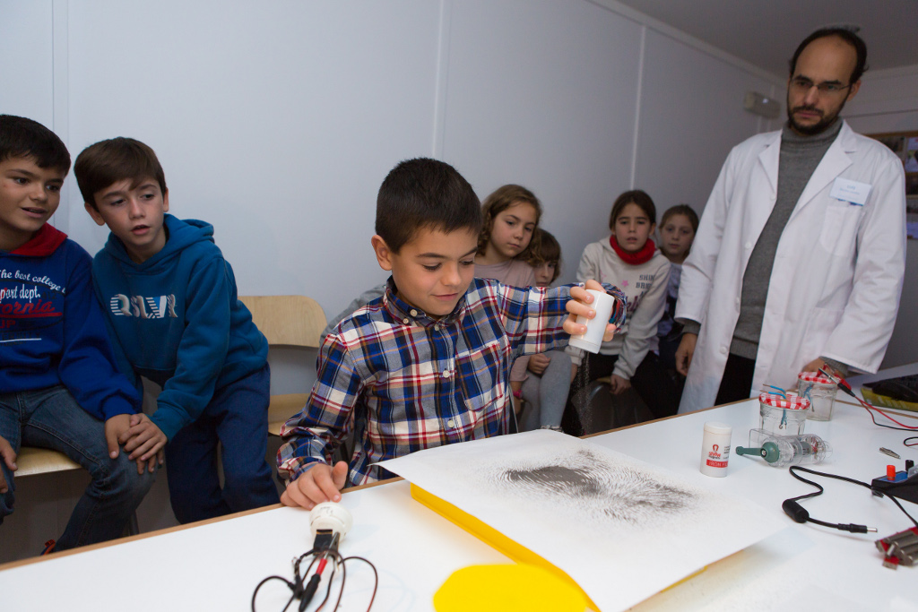 Un escolar de Logroño realiza un experimento ante la atenta mirada del monitor y de sus compañeros.