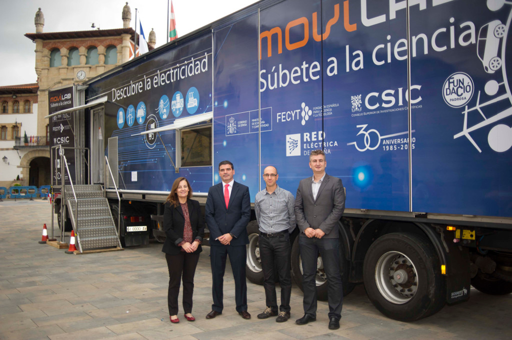 La Directora del Departamento de Cultura Científica de FECYT, el Delegado Regional Norte de Red Eléctrica, el Teniente Alcalde del Área Territorial del Ayuntamiento de Munguía y el Director del Centro de Física de Materiales (CSIC-UPV/EHU), junto al camión, en la presentación del proyecto Movilab en Munguía (Vizcaya).