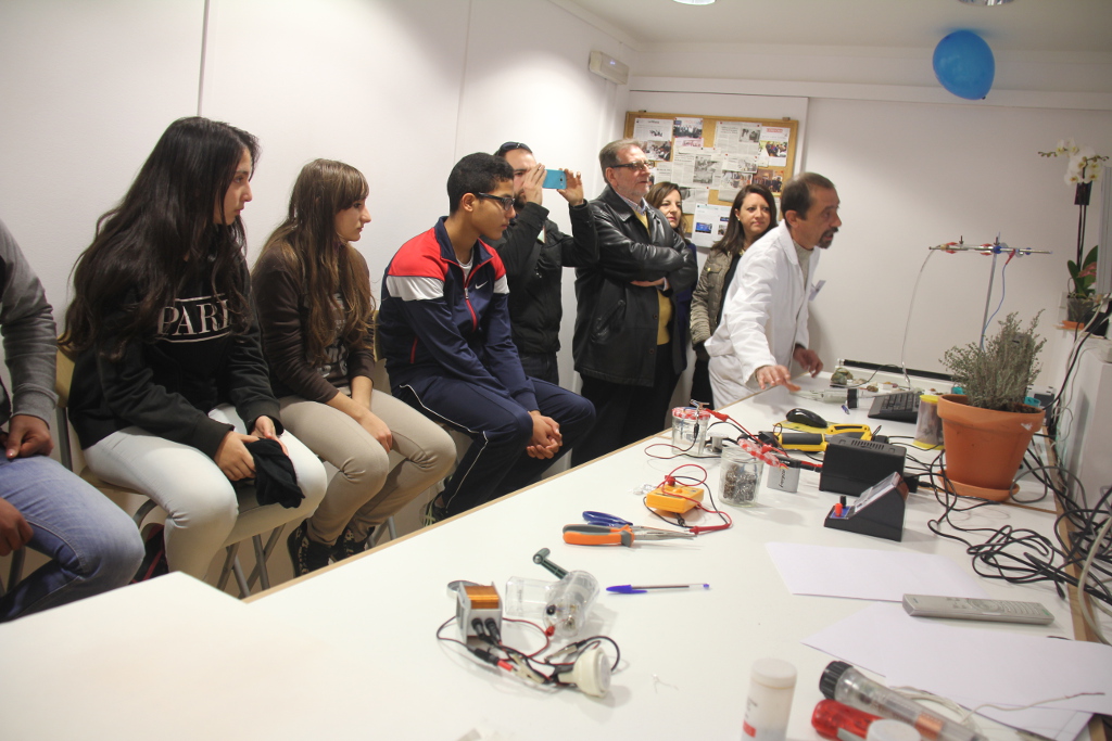 Los escolares de un centro educativo de Torrent (Valencia) observan atentos uno de los experimentos que realiza el monitor.