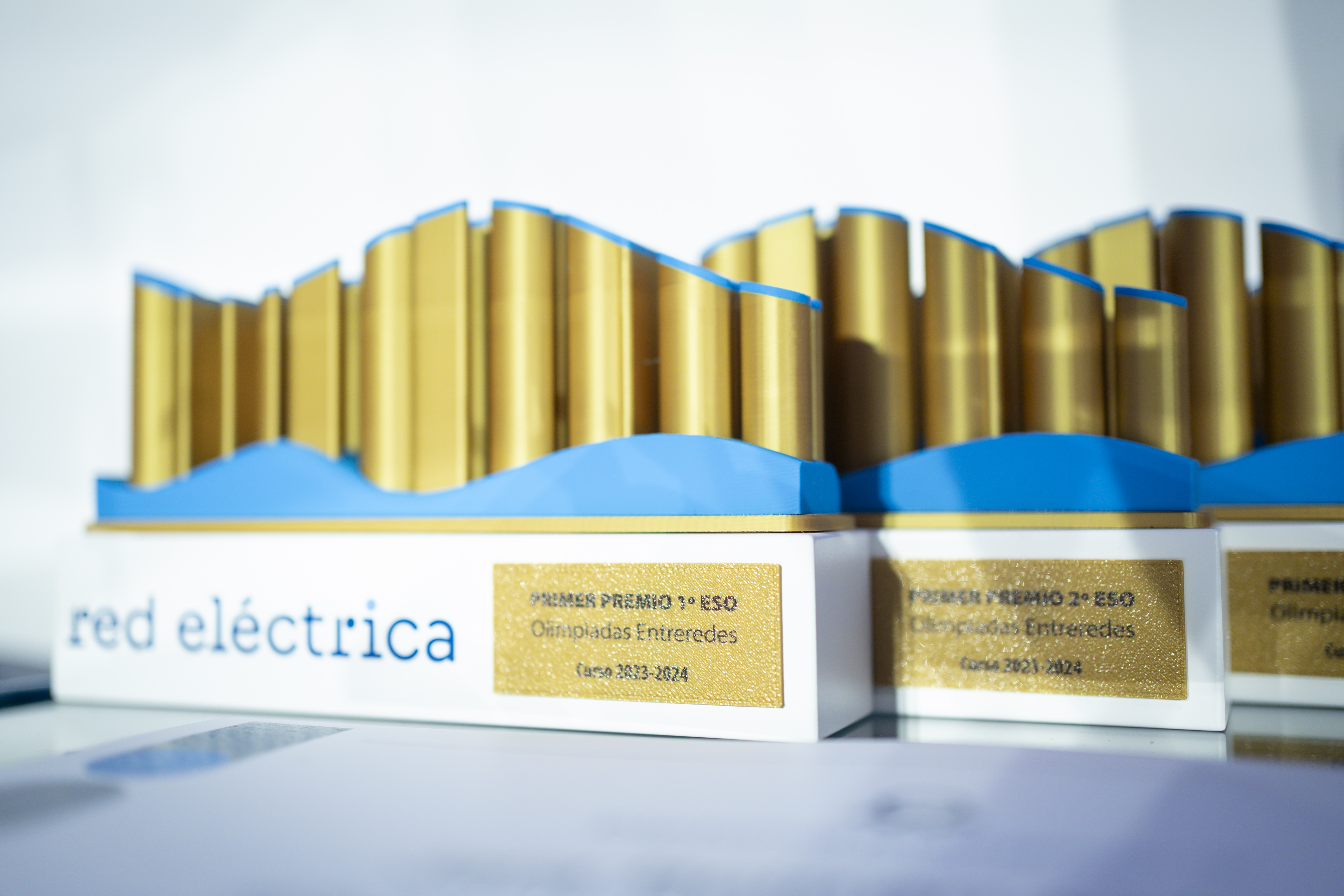 Imagen de los trofeos que se entregan a los centros educativos junto a material didáctico.