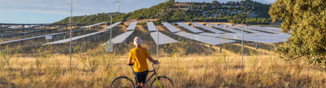 Ciclista mirando unos paneles solares