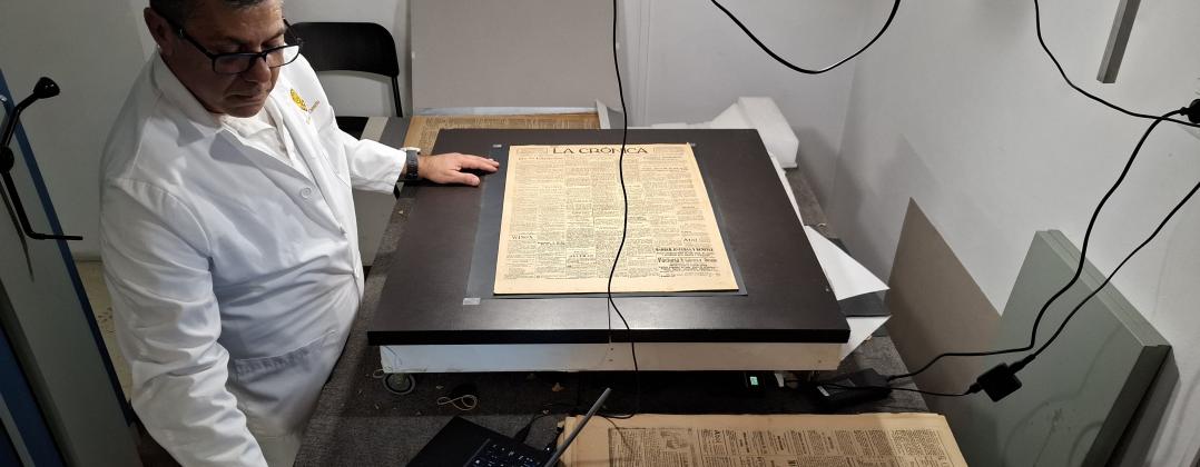 Técnico del museo digitaliza la hemeroteca de papel.