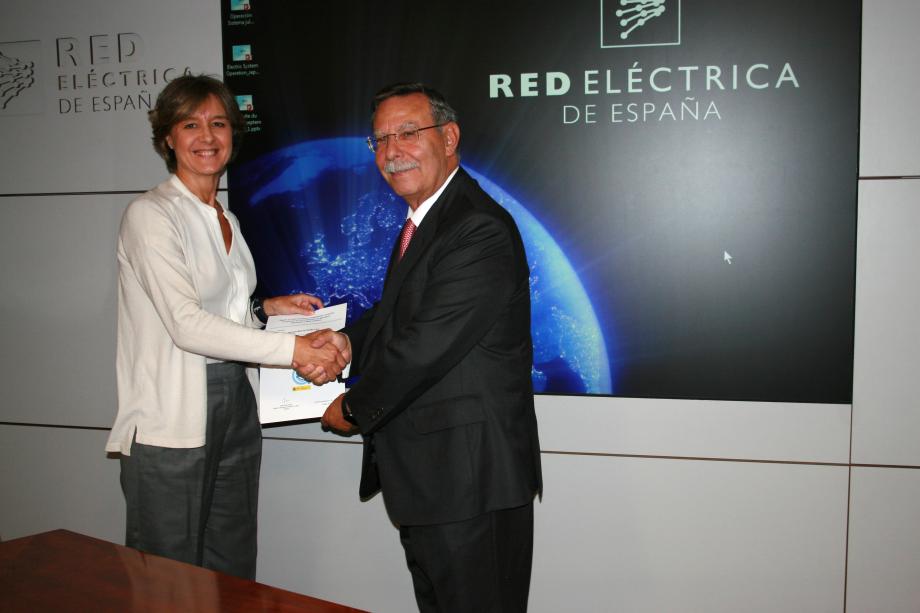 La ministra en funciones de Agricultura, Alimentación y Medio Ambiente, Isabel García Tejerina, entrega al presidente de Red Eléctrica de España, José Folgado, el certificado de inscripción en el registro de huella de carbono.