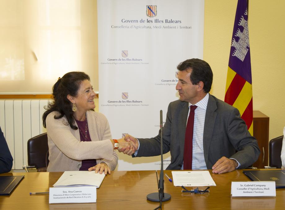 Ana Cuevas, directora de Asuntos Corporativos y Relaciones Institucionales de Red Eléctrica, y Gabriel Company, consejero de Agricultura, Medio Ambiente y Territorio del Gobierno Balear, se saludan tras la firma de los convenios.