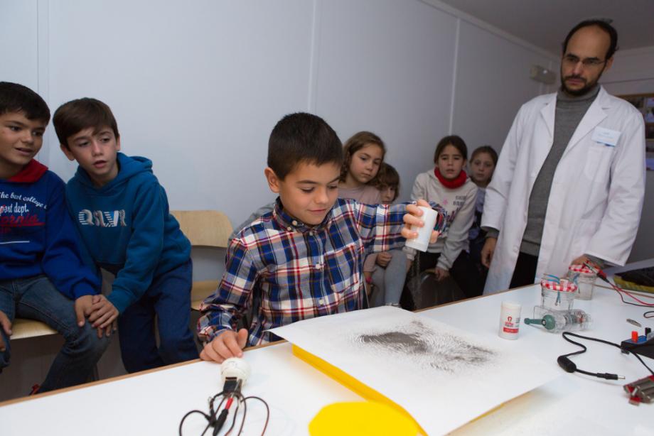 Un escolar de Logroño realiza un experimento ante la atenta mirada del monitor y de sus compañeros.